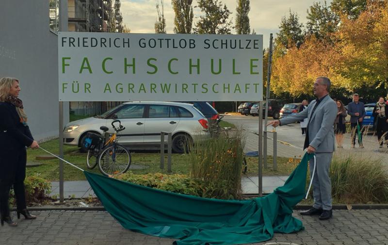 Landwirtschaftsministerin Susanna Karawanskij und Peter Ritschel  enthüllen das neue Namensschild der Schule
