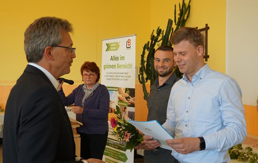 Steffen Fleischack (r.) übergibt Abschlusszeugnisse an den Jahrgangsbesten Landwirt Julius Nicklas von der Nicklas Hof GbR in Herbsleben und Paul Schich (Agrargenossenschaft „Am Ohmberg“) 